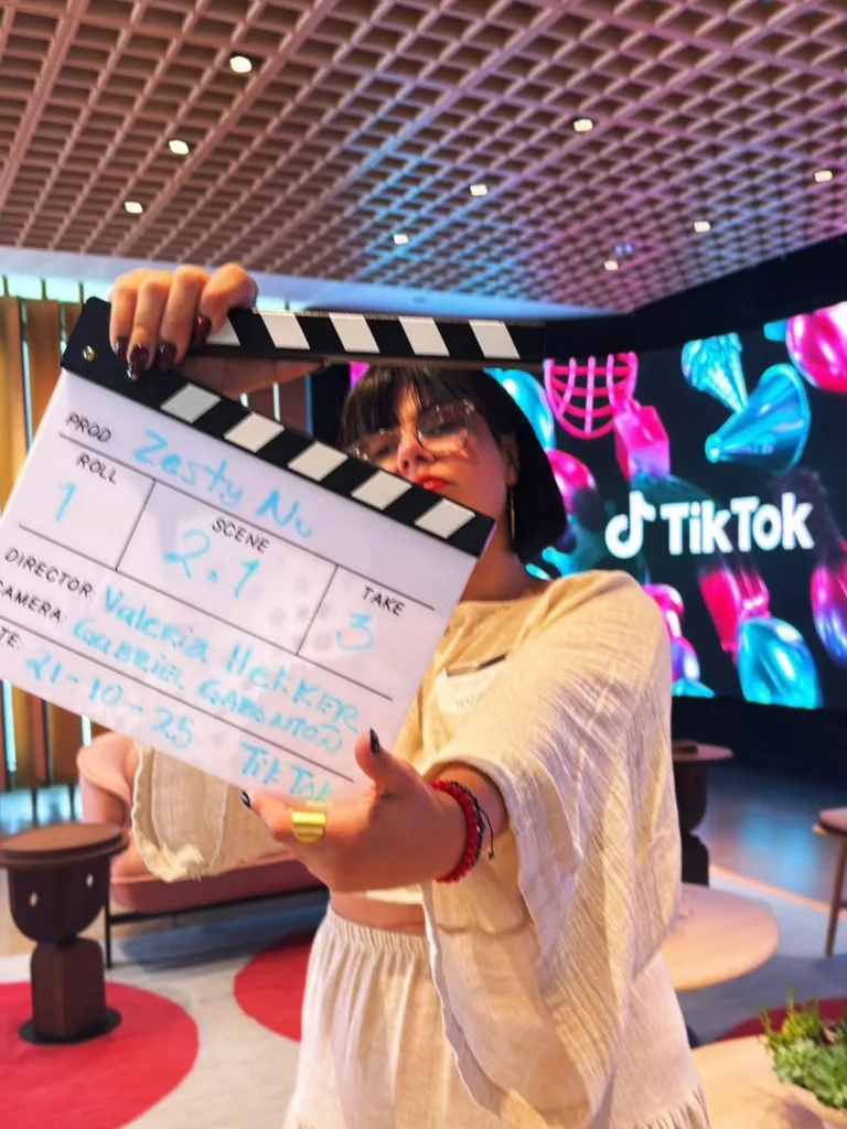 Valeria Hekker en producción audiovisual con clapperboard y logo de TikTok