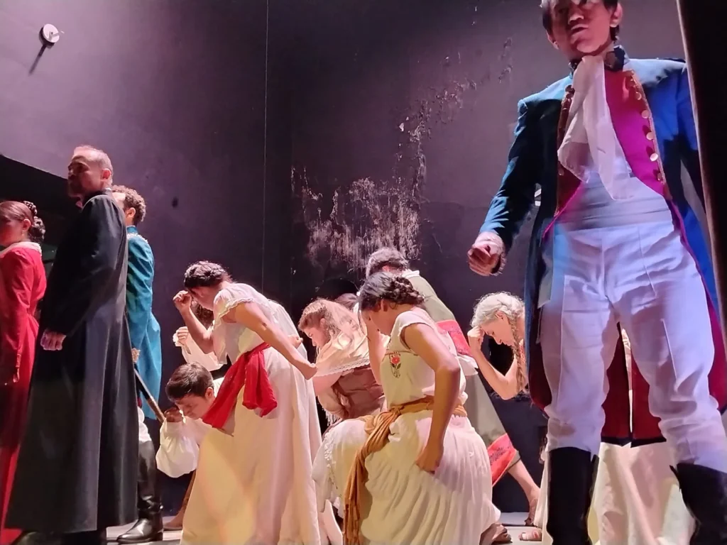 Escena teatral en el Teatro La Carreta de Tespys en Querétaro, con actores en vestuario histórico durante el montaje de la obra musical Josefa.