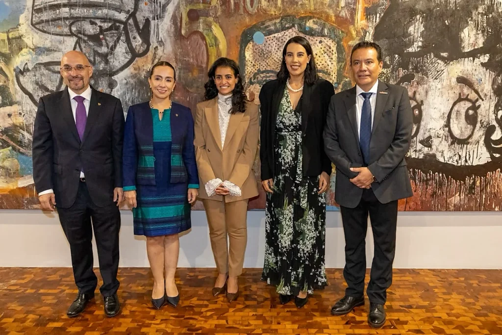 Autoridades y representantes culturales frente a obra artística durante encuentro de turismo comunitario.