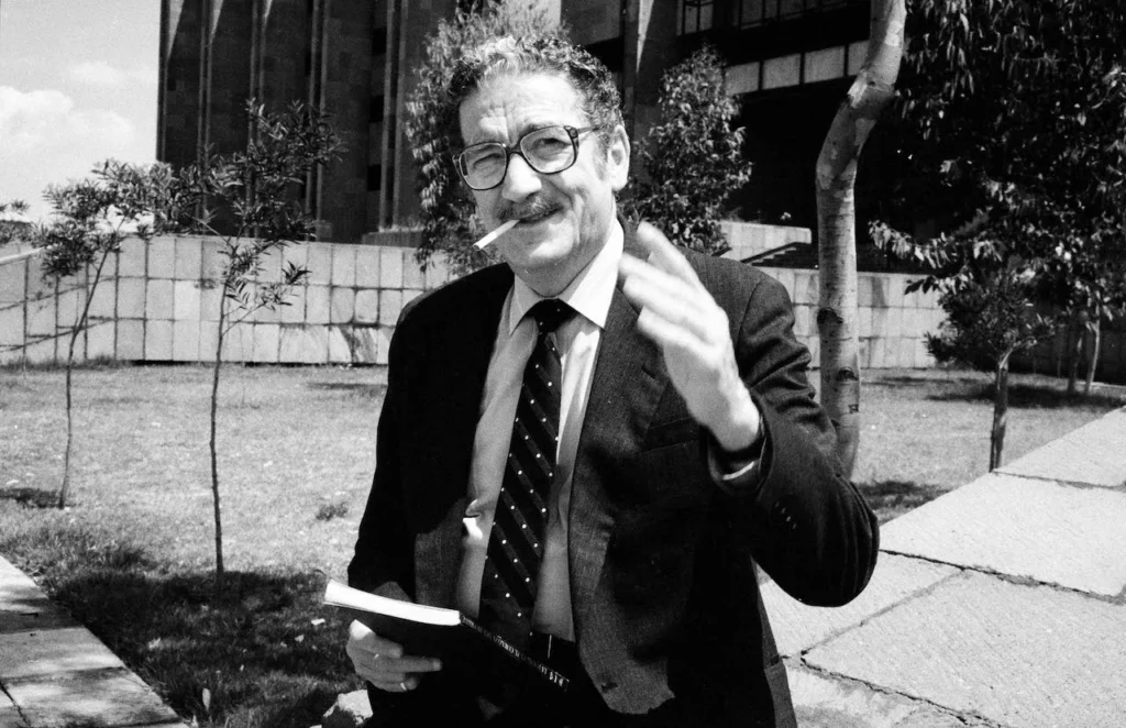 Fotografía de Jaime Sabines durante una actividad pública. El poeta mexicano aparece sosteniendo un libro en una imagen histórica utilizada en las conmemoraciones por el centenario de su nacimiento.