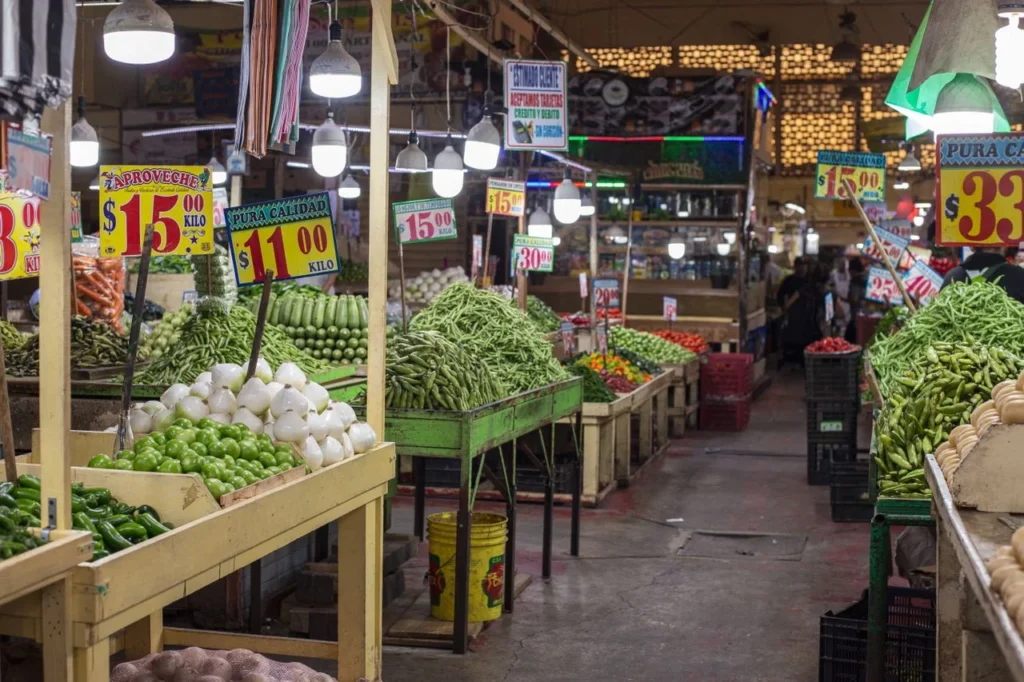 Mercado mexicano con verduras frescas y precios visibles, reflejo del consumo cotidiano y del desperdicio de alimentos.