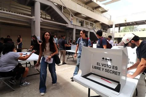 Ciudadanos mexicanos participan en una jornada electoral ejerciendo su derecho al voto en una casilla.